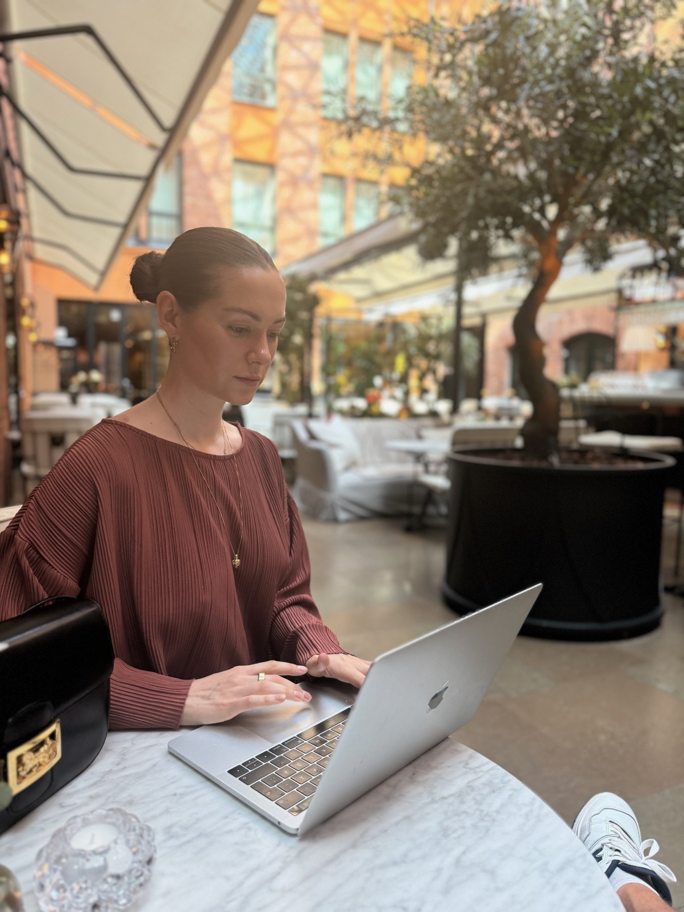 Hanna Grönstedt working at a marble table in a hotel courtyard